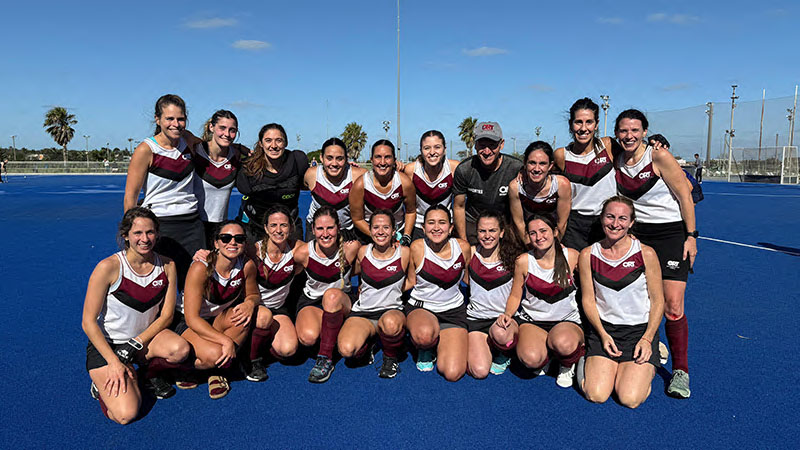 Equipo femenino de hockey campeón posa para foto donde estan las integrantes del equipo